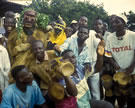 Two <em>genu</em> from Petit Gbapleu at a <em>Gebian</em>, or Racing Mask Competition, with drummer Semlen Aimé, Man, Cote d'Ivoire, 1997. Image © Daniel Reed.