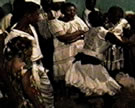 A <em>manbo</em> (female Vodou priest) is possessed by Gede, spirit of the dead, during a ritual in Port-au-Prince, Haiti, 1995. Image from video © Lois Wilcken.