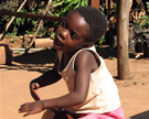 Elelwani Michelle Mutangwa, a Venda child from Tshakuma Village, plays the <em>murumba</em> drum and sings <em>ngano</em> (folklore) children's songs.  Limpopo Province, South Africa, 2007. Image © Andrea Emberly.
