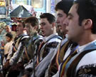 Young men of the village Calușer group sing in their church before proceeding to visit houses throughout the community, Oraștioara de Jos, Romania, 1998. Image from video © Colin Quigley.